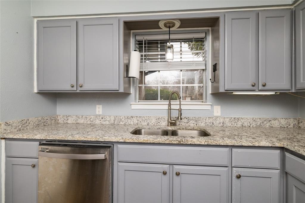 6020 Harrison Way Watauga, TX 76148 - Photo 18 of 32 Kitchen featuring gray cabinets, stainless steel dishwasher, and light stone counters