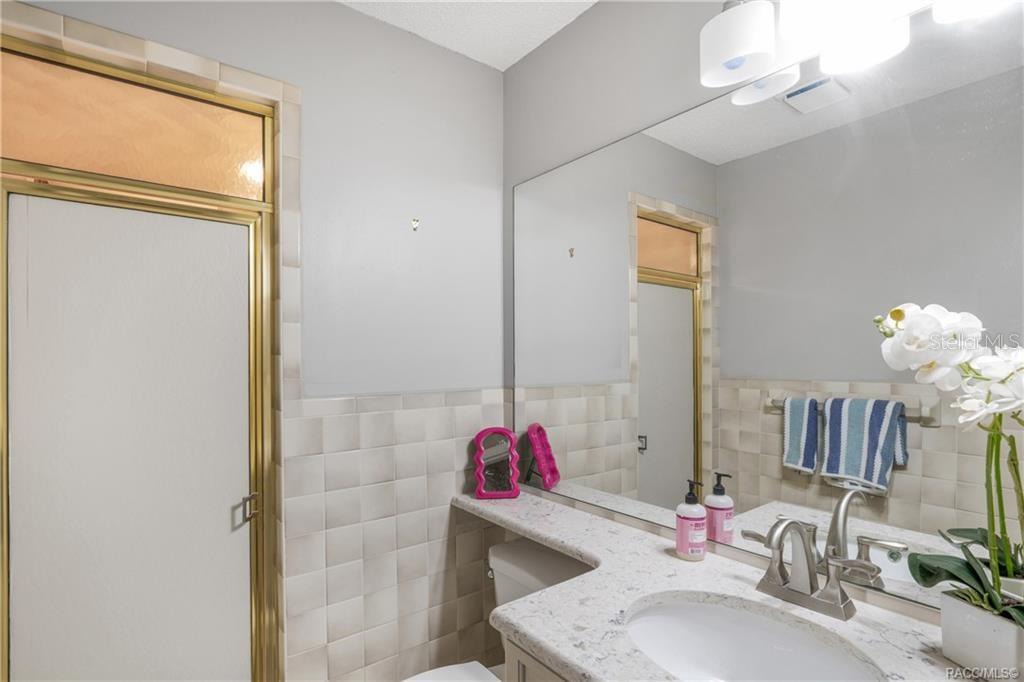 8831 East Sandpiper Drive Inverness, FL 34450 - Photo 24 of 44 a bathroom with a sink vanity mirror and shower