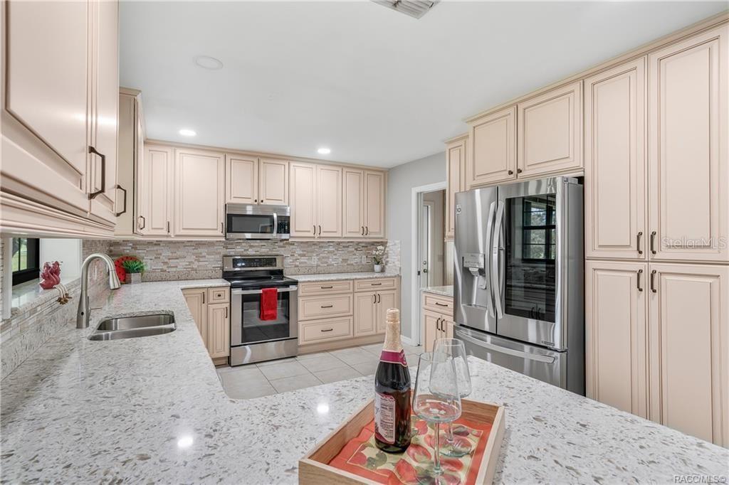 8831 East Sandpiper Drive Inverness, FL 34450 - Photo 7 of 44 a kitchen with stainless steel appliances kitchen island granite countertop a refrigerator oven stove a sink and dishwasher