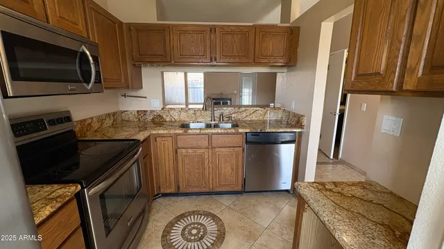 a kitchen with stainless steel appliances granite countertop a refrigerator stove and sink