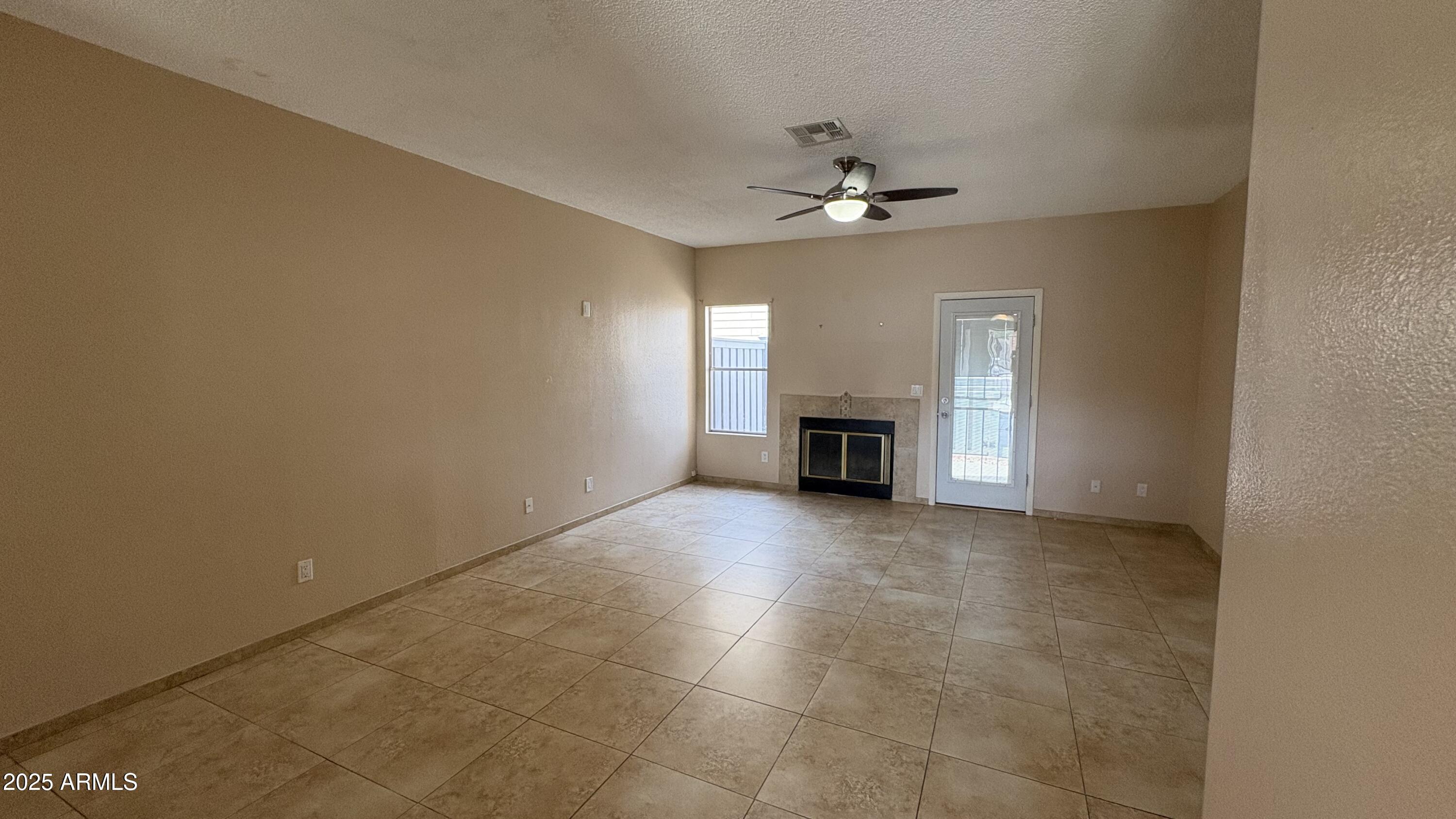 18626 North 33rd Drive, Unit 1 Phoenix, AZ 85027 - Photo 13 of 38 an empty room with a ceiling fan and a fireplace