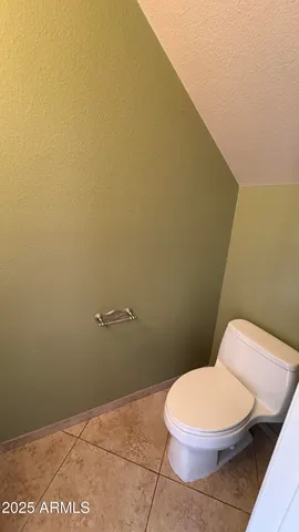a white toilet sitting next to a white wall