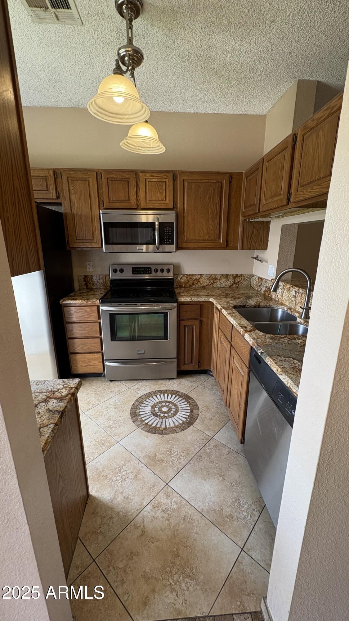 18626 North 33rd Drive, Unit 1 Phoenix, AZ 85027 - Photo 6 of 38 a kitchen with stainless steel appliances granite countertop a stove a sink dishwasher and a refrigerator