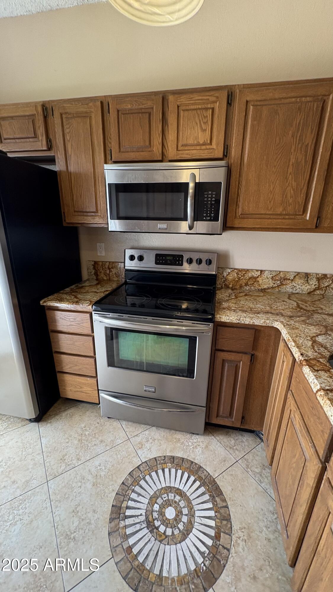 18626 North 33rd Drive, Unit 1 Phoenix, AZ 85027 - Photo 8 of 38 a kitchen with granite countertop a stove and a microwave