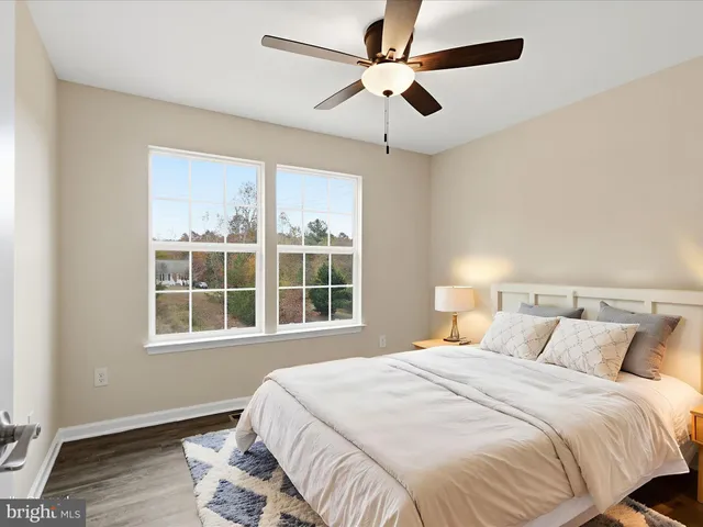 a bedroom with a bed and a large window with potted plants