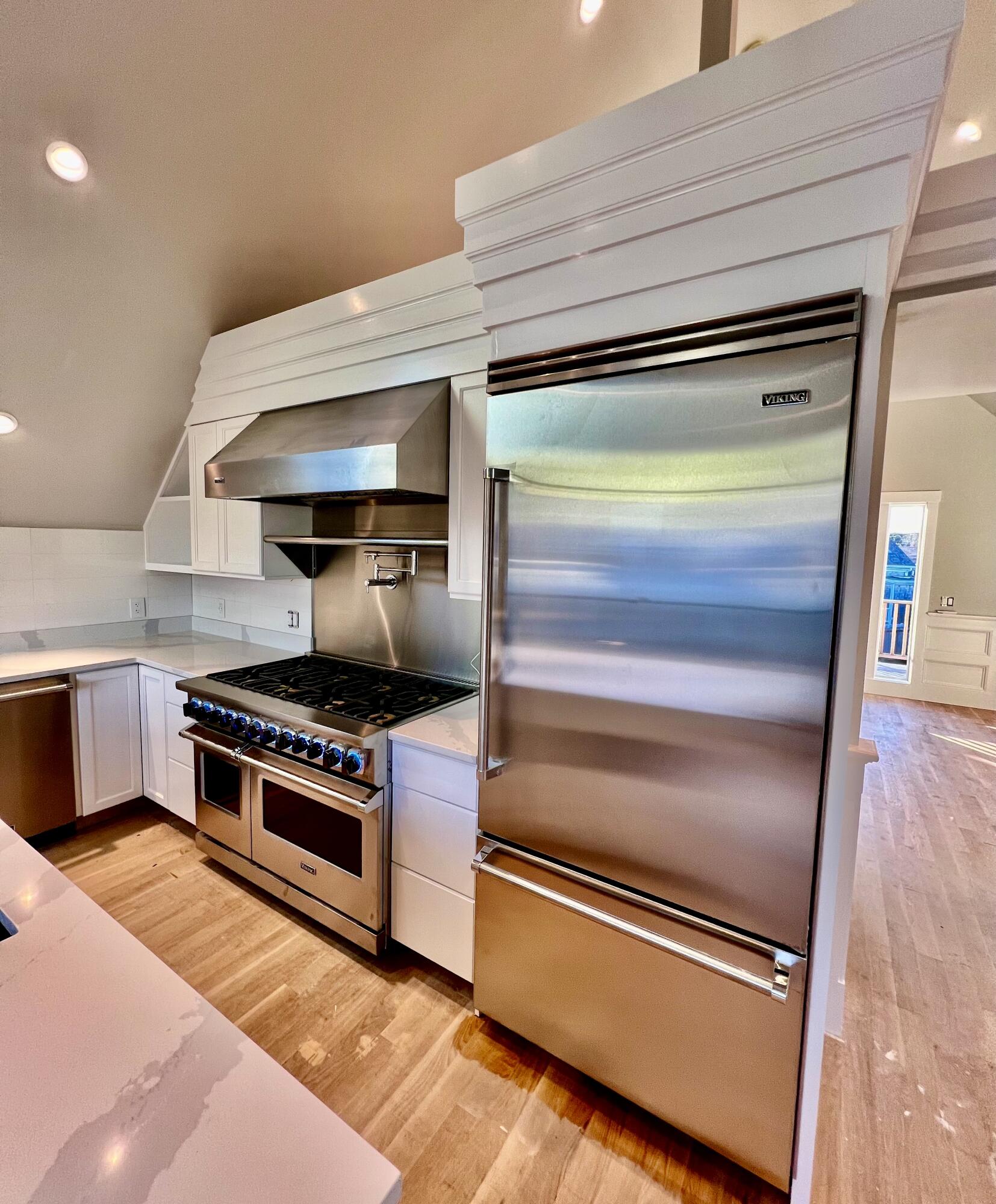6 Race Road Provincetown, MA 02657 - Photo 10 of 30 a kitchen with wooden floor and stainless steel appliances