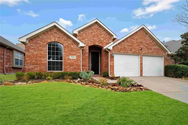 a front view of a house with a garden and yard