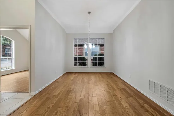 a view of a room with wooden floor chandeliers and a window