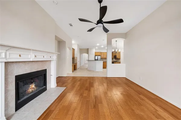 a view of empty room with wooden floor fireplace and a window