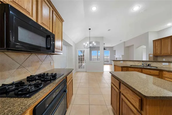 a kitchen with a stove a sink and a microwave