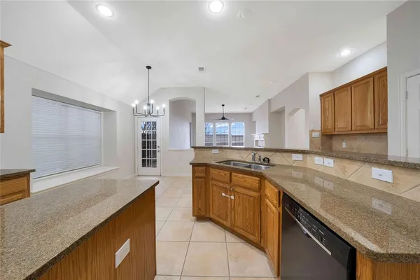 a large kitchen with granite countertop a sink counter space cabinets and stainless steel appliances