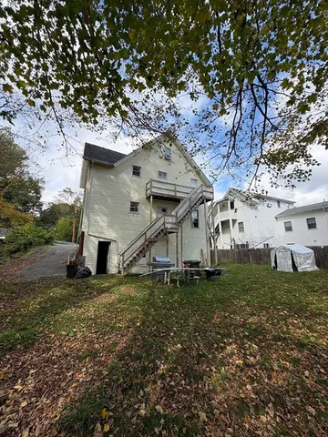 a white house that has a tree in front of it