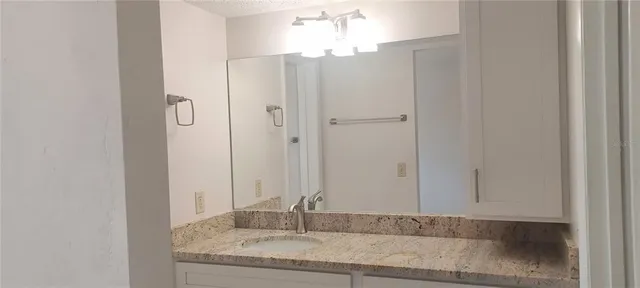 a bathroom with a granite countertop mirror and shower