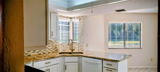 a bathroom with a granite countertop sink and a window