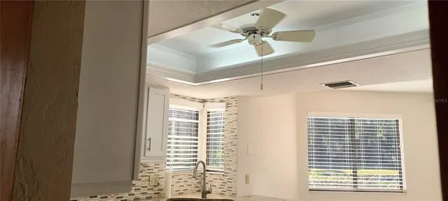 a view of an empty room with a window and a ceiling fan