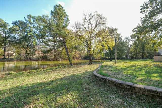 a view of a swimming pool with a yard and trees