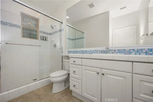 a bathroom with a granite countertop sink a toilet and a mirror