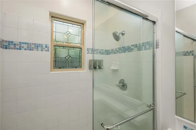 a bathroom with a glass shower door and mirror