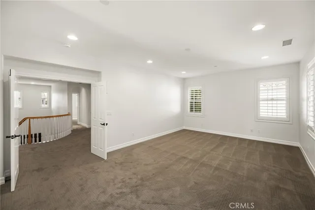 an empty room with windows and mirror