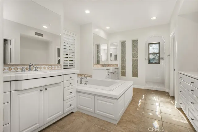 a spacious bathroom with a bathtub sink and mirror