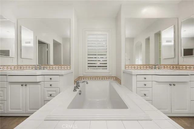 a spacious bathroom with a sink a mirror a vanity and a bathtub