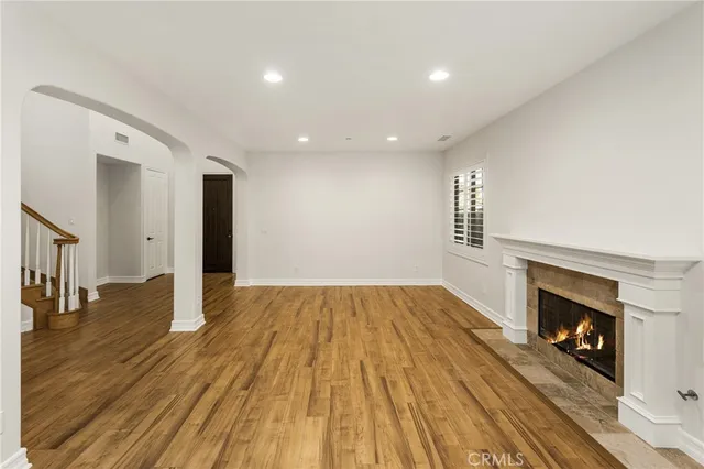 a view of empty room with wooden floor and fireplace