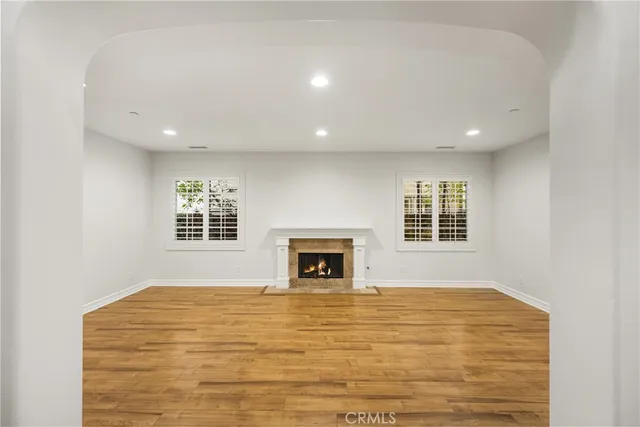 a view of an empty room with a window and fireplace