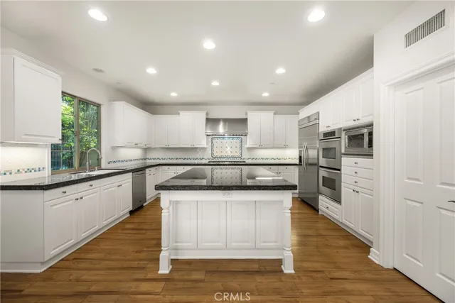 a large kitchen with stainless steel appliances granite countertop a large center island attached withe living room