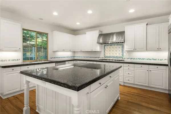 a kitchen with granite countertop a sink a counter space appliances and cabinets