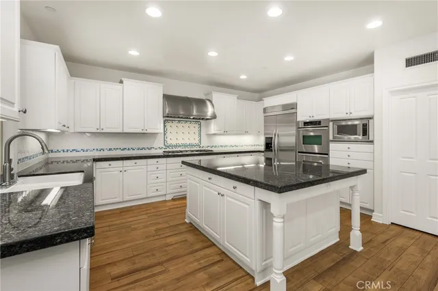 a kitchen with granite countertop a sink and cabinets