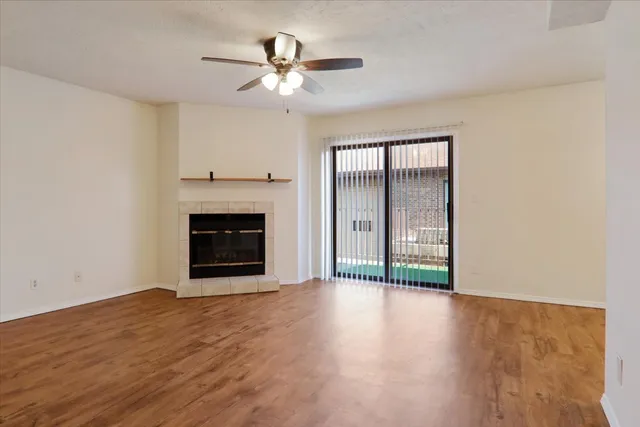 a view of an empty room with a fireplace and a window