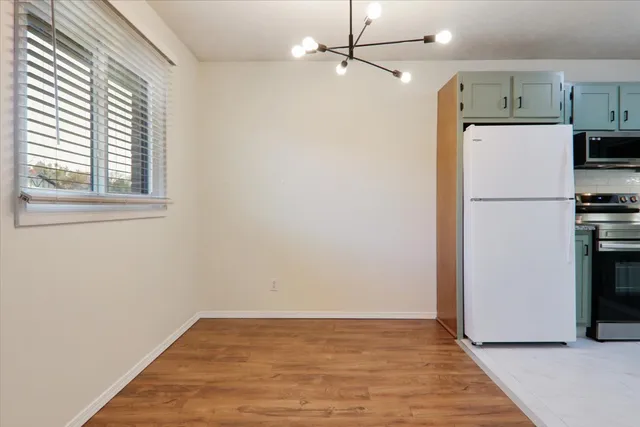 a view of empty room with wooden floor and window