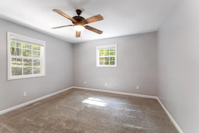 an empty room with closet and windows