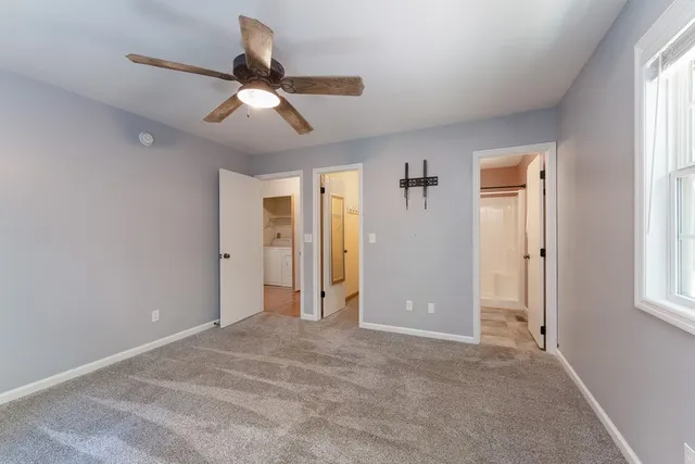 a view of empty room with window and ceiling fan