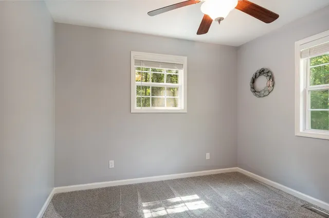 an empty room with closet and a chandelier fan