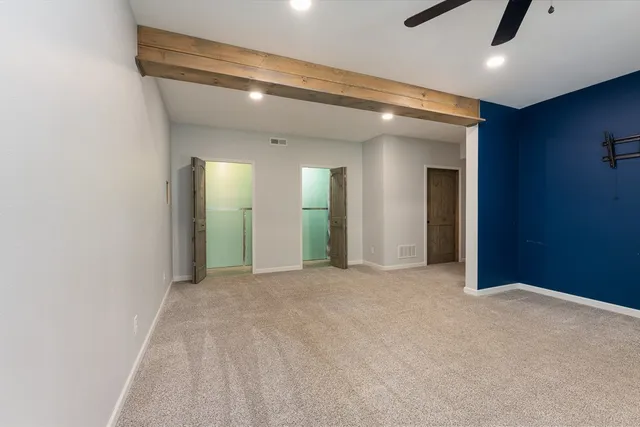 an empty room with windows and a ceiling fan