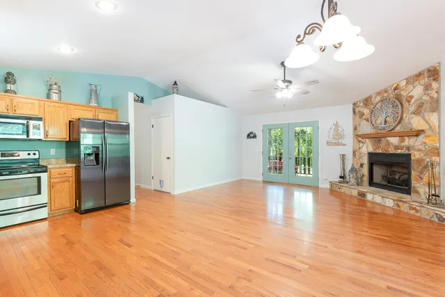 a view of an empty room with a fireplace and a window
