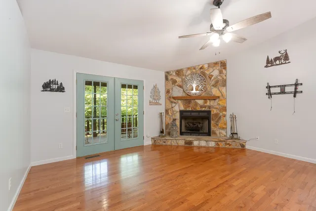 wooden floor fireplace and windows in an empty room