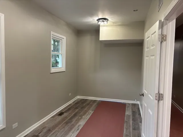 a view of room with window and wooden floor