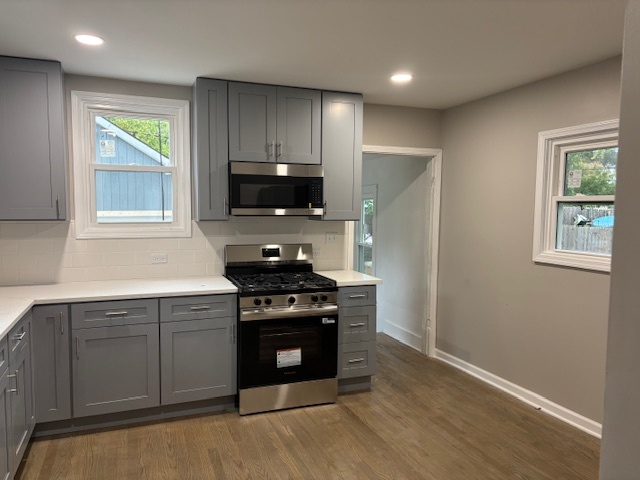 456 Franklin Boulevard Elgin, IL 60120 - Photo 4 of 32 a kitchen with stainless steel appliances a stove a sink and a microwave