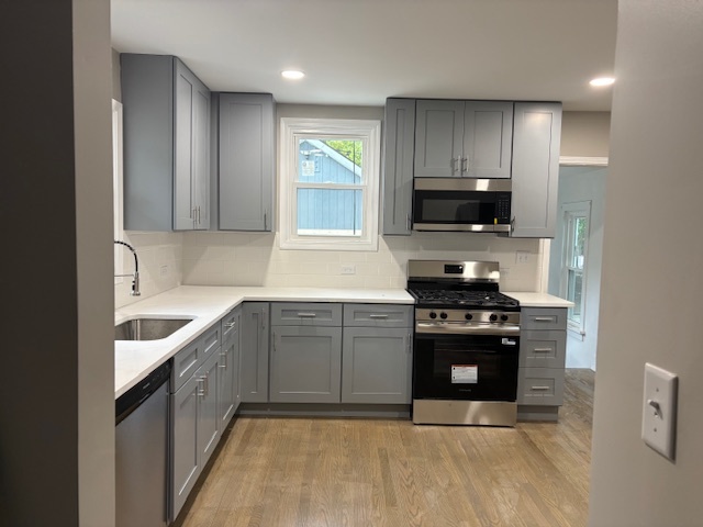 456 Franklin Boulevard Elgin, IL 60120 - Photo 7 of 32 a kitchen with granite countertop a stove a sink and a microwave