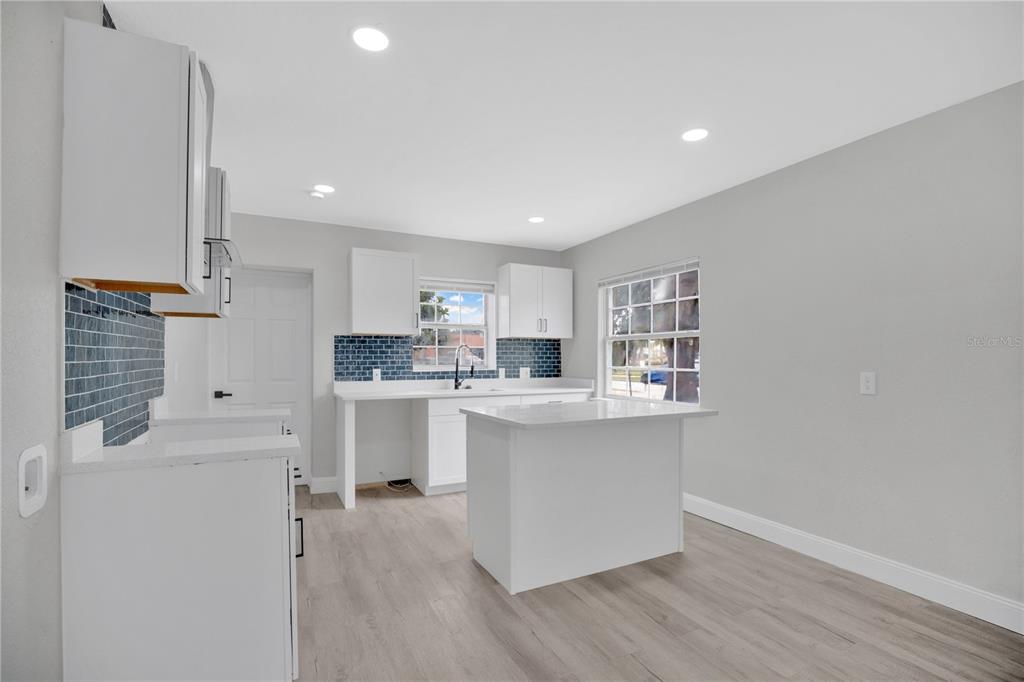 911 Indiana Street Orlando, FL 32805 - Photo 7 of 24 a kitchen with white cabinets and sink