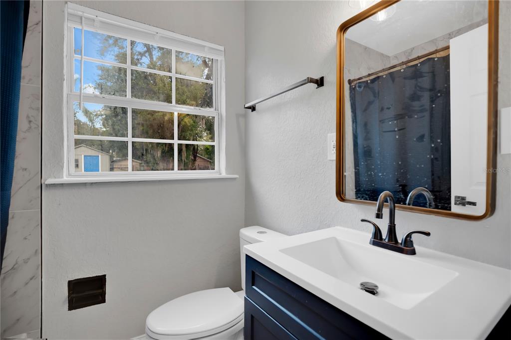 911 Indiana Street Orlando, FL 32805 - Photo 10 of 24 a bathroom with a sink toilet and mirror