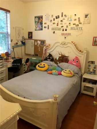 a bed sitting in a bedroom next to a window