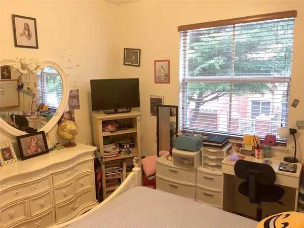a living room with furniture a flat screen tv and floor to ceiling window
