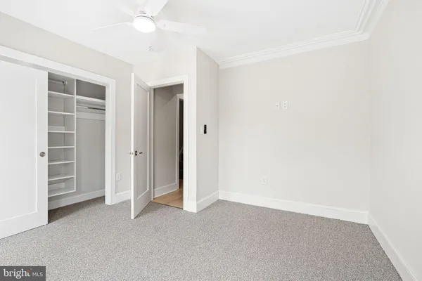 an empty room with windows and ceiling fan