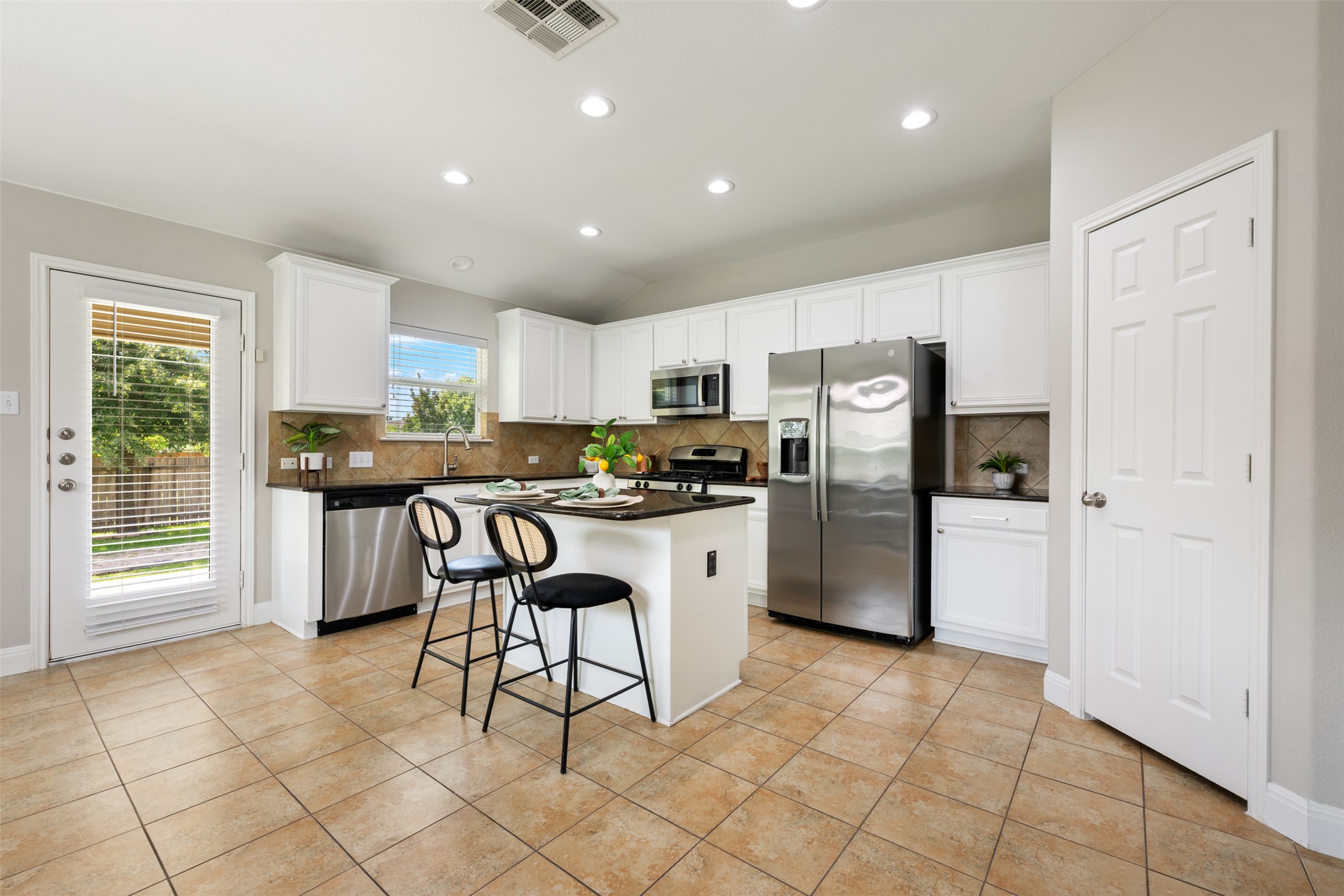 18820 Edinburgh Castle Road Pflugerville, TX 78660 - Photo 15 of 37 a kitchen with stainless steel appliances granite countertop a refrigerator and a stove top oven