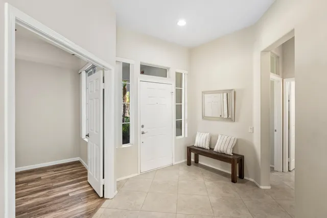 a view of a hallway with dining area and chandelier