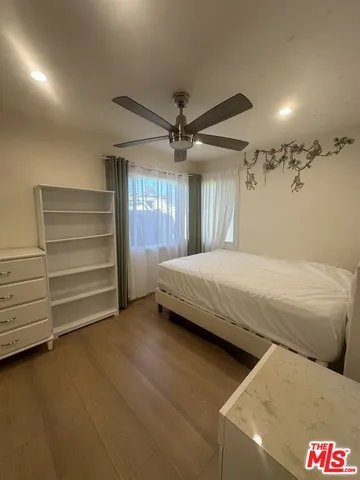 a bedroom with a bed and a ceiling fan