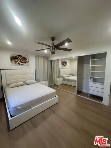 a bedroom with a bed and a ceiling fan